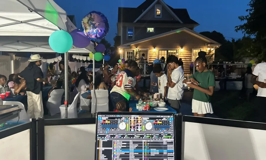 Backyard party at dusk with balloons and guests